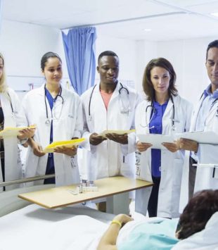 Doctor and residents examining patient in hospital room