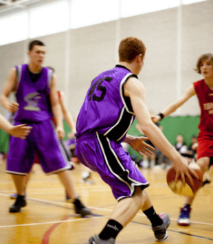 atletas universitários jogando basquete