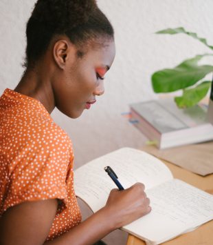 Mulher negra escrevendo em frente ao computador - personal statement