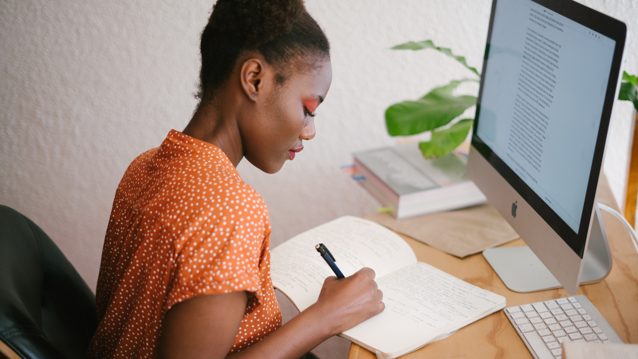 Mulher negra escrevendo em frente ao computador - personal statement