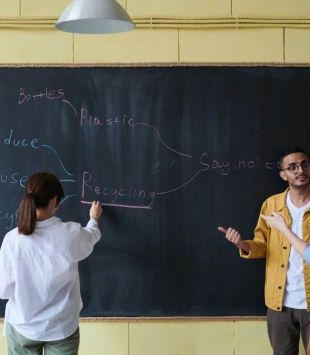 professores conversando em frente a uma lousa